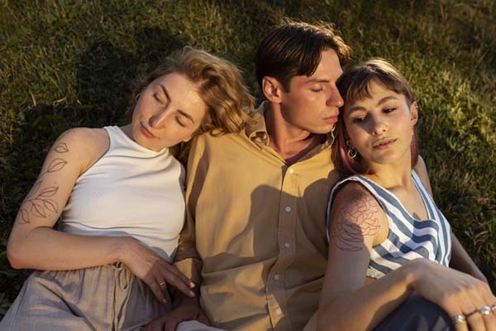 Polyamorous couple spending time together outdoors in the par